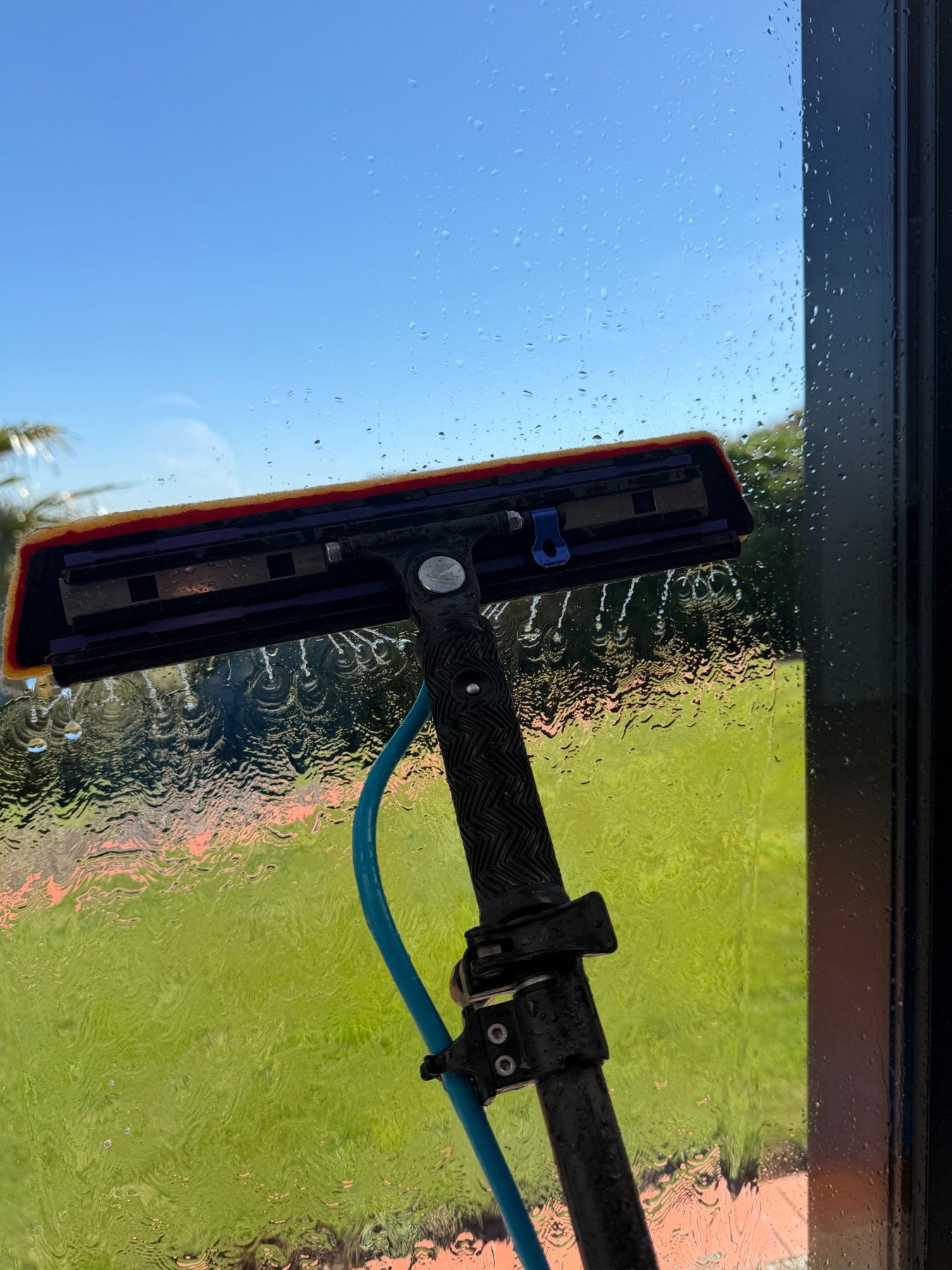 Professional water-fed cleaning head against glass